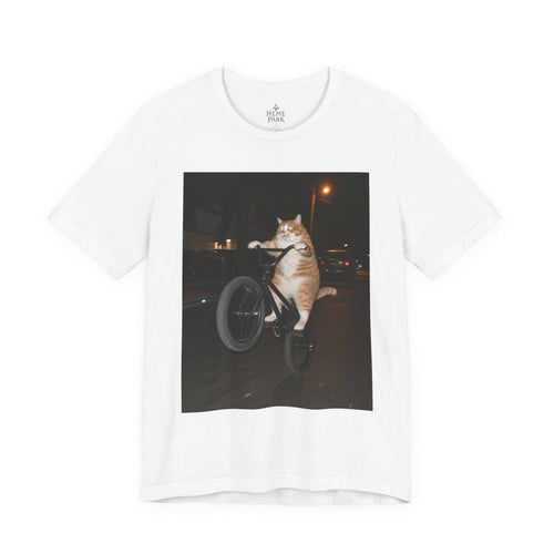 White BMX Cat Tee, front view with an orange-and-white cat doing a bicycle wheelie at night.